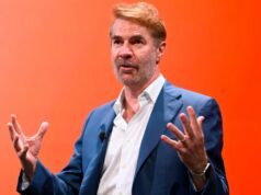আমাদের কি জেনারেটিভ এআই দরকার?
| BanglaKagaj.in Erik Brynjolfsson gestures while speaking onstage during a panel, with a vivid orange background behind him.