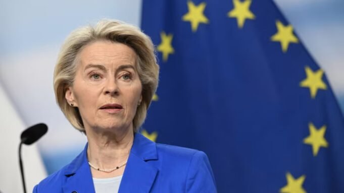 Ursula von der Leyen speaks at a press conference, with a European Union flag visible in the background